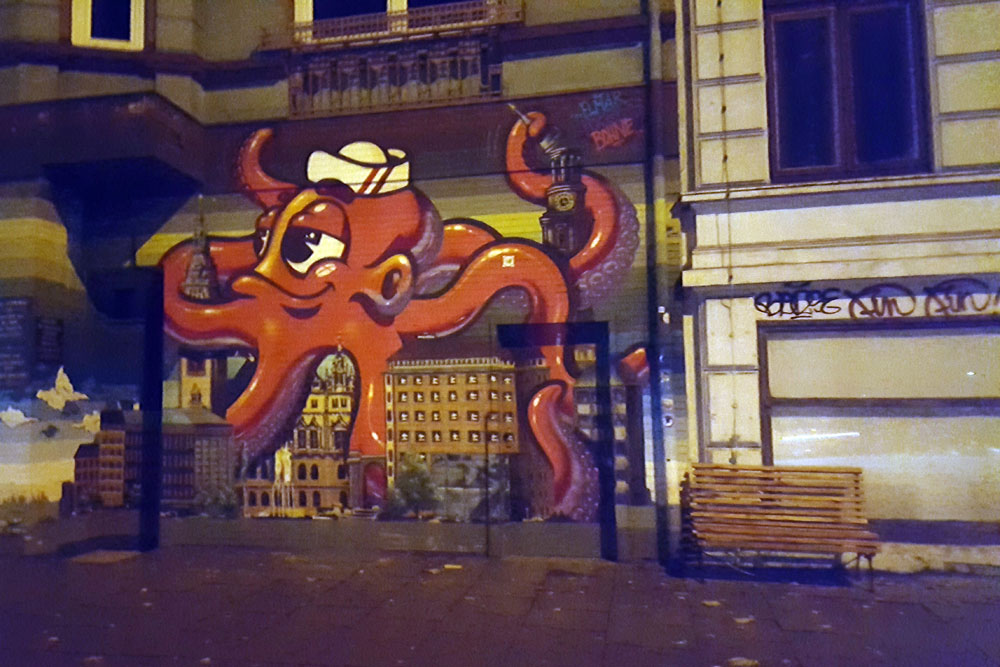 Rote-Krake-Graffiti an einer Hauswand in einer Seitenstraße in St. Pauli