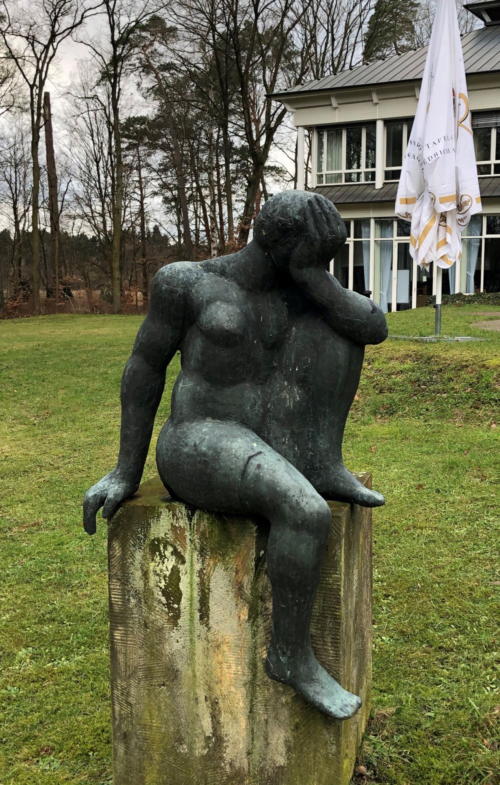 sitzende Frau im Garten des Hotels  in der Uckermark - Bronze-Skulptur des Bildhauers Werner Stötzer 