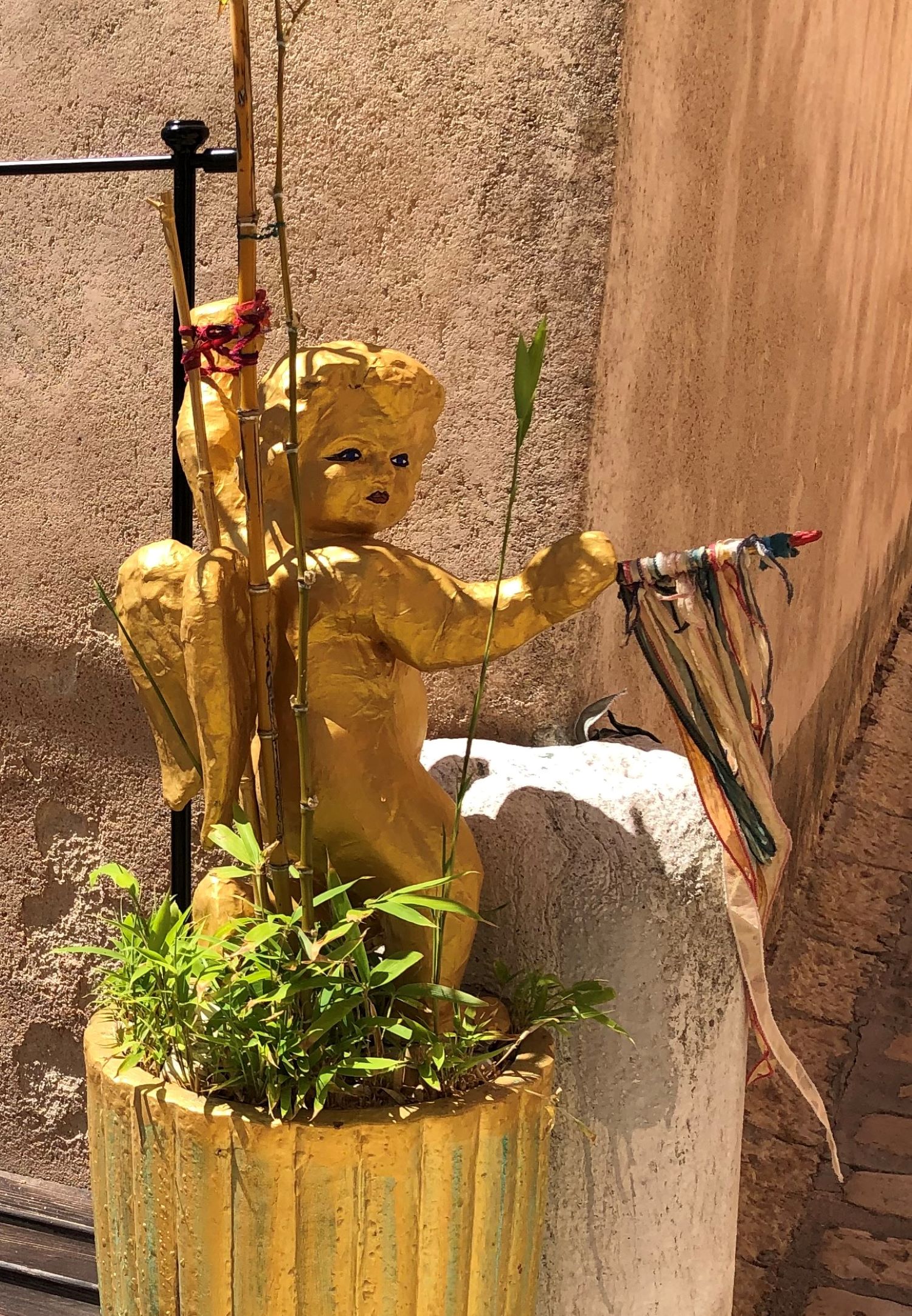 Dekoration "Goldener Engel" in einem Blumentopf in einer Gasse