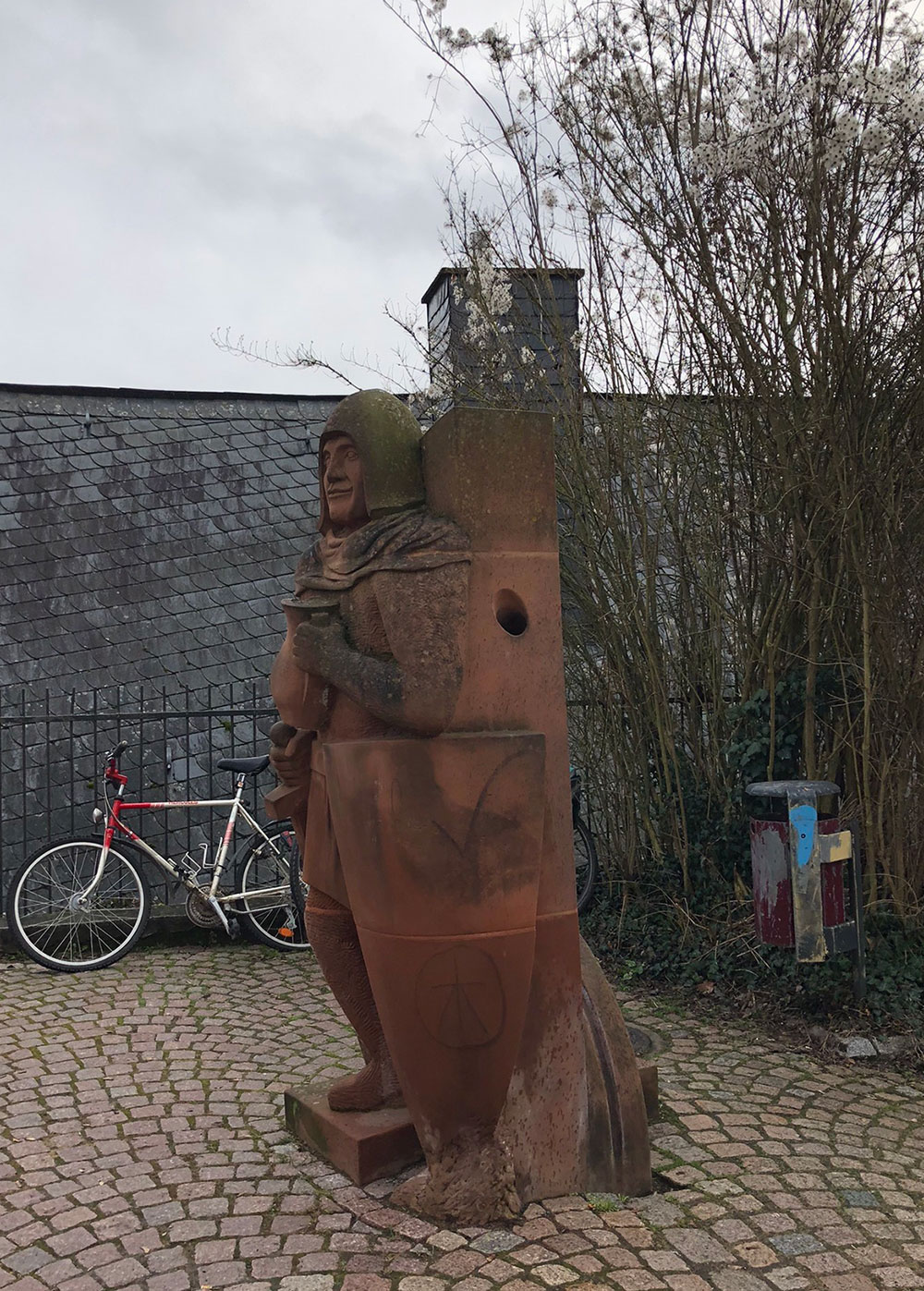 Ritterfigur als Trinkwasserbrunnen aus rotem Sandstein von der Bildhauerei Trautmann in Marburg
