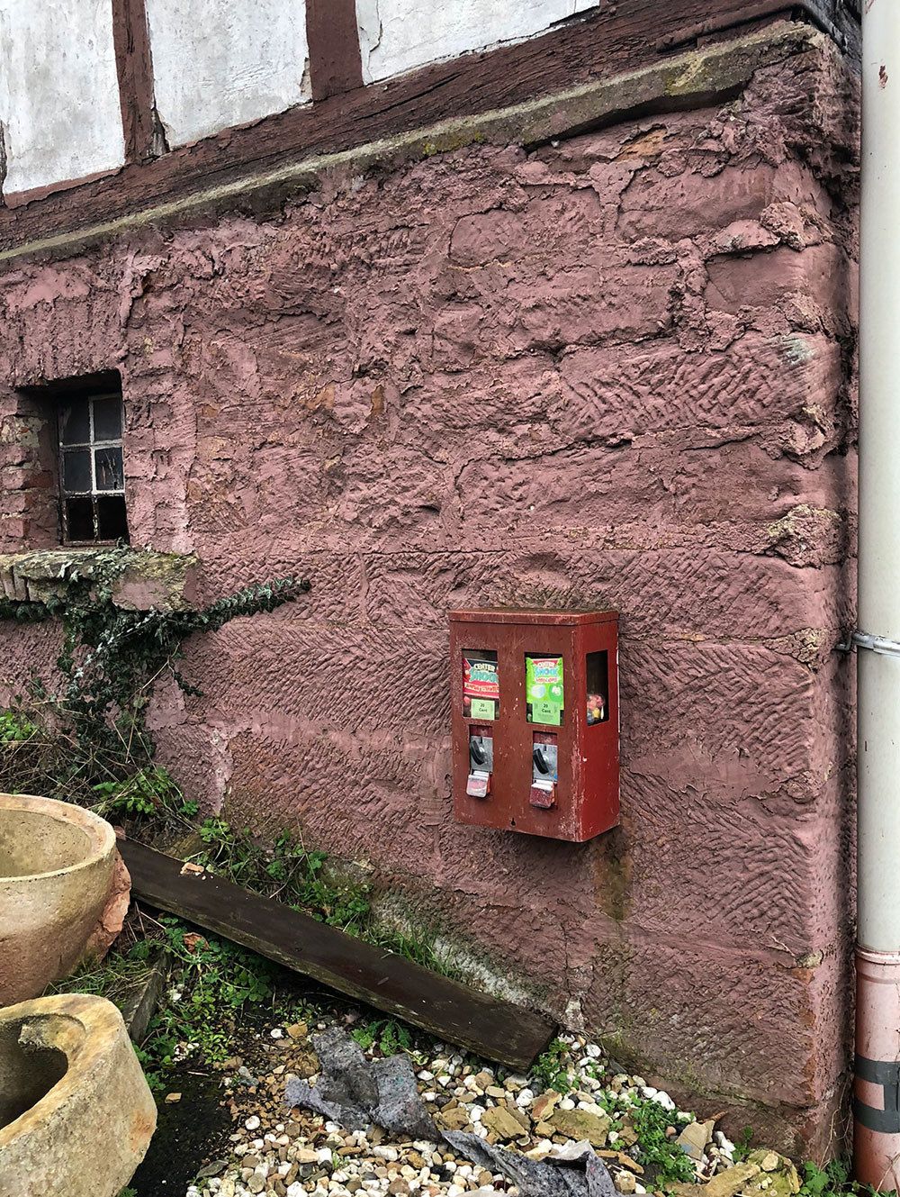 rote Kaugummiautomaten an einer roten Hauswand in Wehrshausen