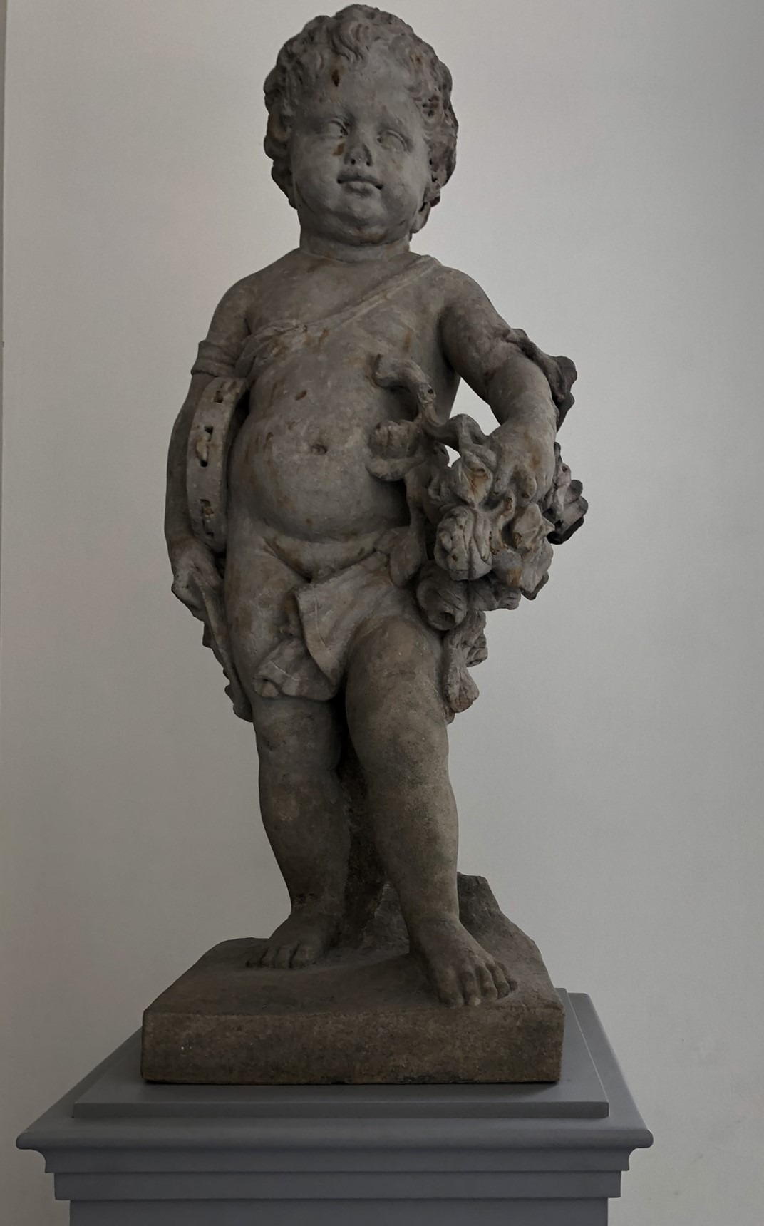 Putto mit Schellentamburin, Maske und Blumengewinden - Sandstein-Statue von Andreas Schlüter in der Kameckehalle (1711/1712).